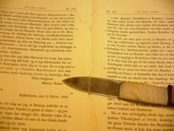 Tråde tages ud af bog hos bogbinderi, så bogbinder binder bogen ind