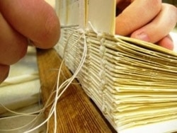 Bogbinderi foretager håndhæftning i forbindelse med indbinding af bøger