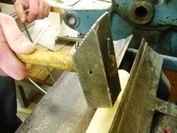 Bøgerne får banket fals, så bogryggen bedre kan sættes fast og holdes skarp af bogbinderen